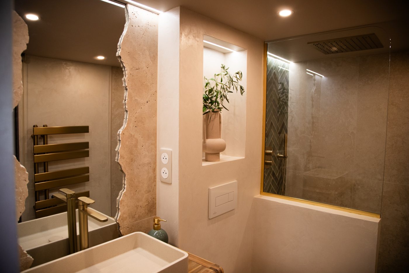 Salle d'eau en pierre avec douche à l'italienne et vasque